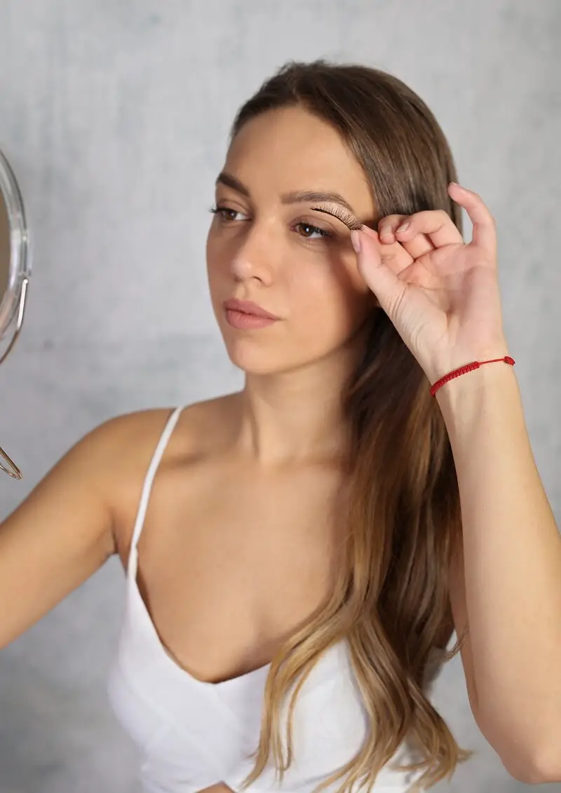 young woman applying self-adhesive eyelashes