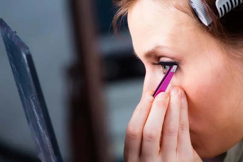 woman using a false lash applicator