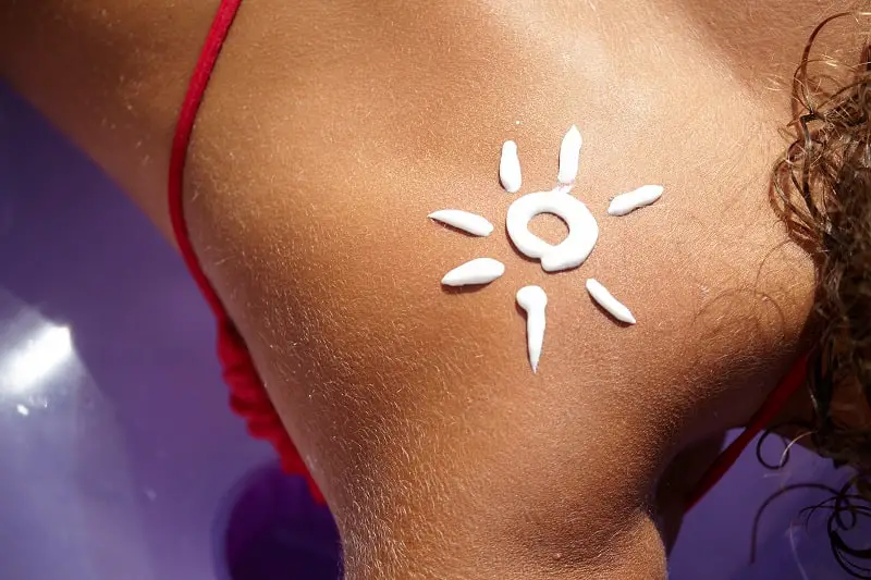 close-up of a woman suntanning with sunscreen on her back