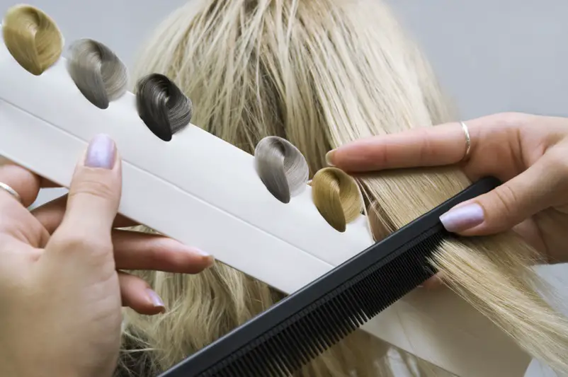 woman toning her hair twice, female client and hairdresser choose tone of hair in salon